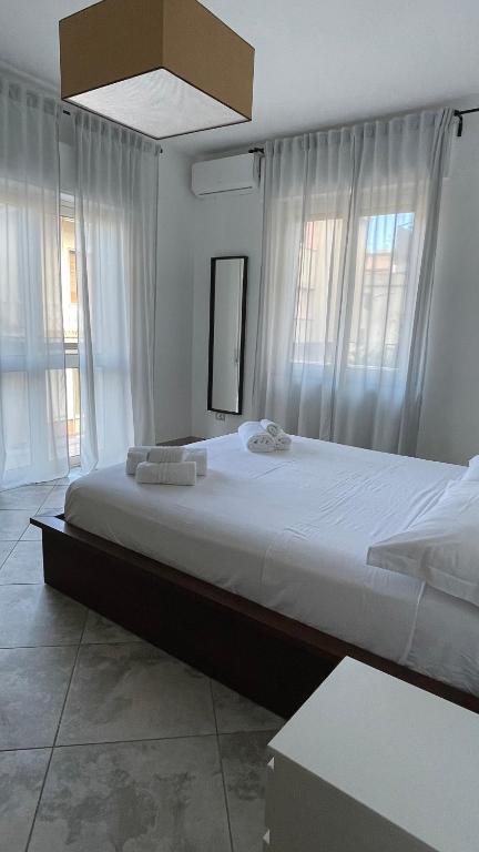 a large bed in a room with windows at LT Apartment Tropea in Tropea