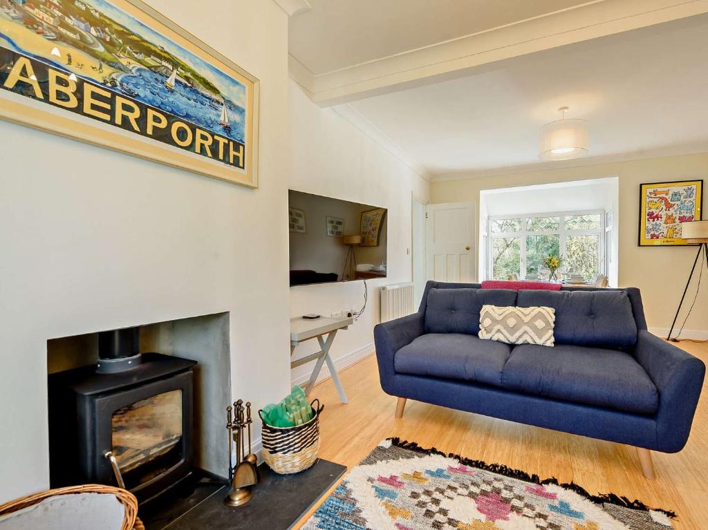 a living room with a blue couch and a fireplace at 4 Bed in Aberporth 93783 in Aberporth