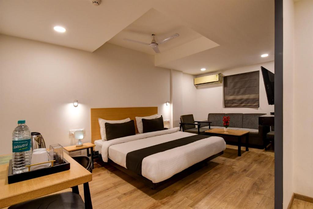 a hotel room with a bed and a living room at Super Townhouse City Centre 2 Downtown - Managed by Company in Kolkata