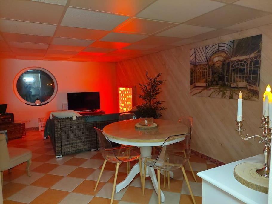 uma sala de jantar com uma mesa e cadeiras num quarto em «Gîte H2O SPA» à Précy-sur-Oise. em Précy-sur-Oise