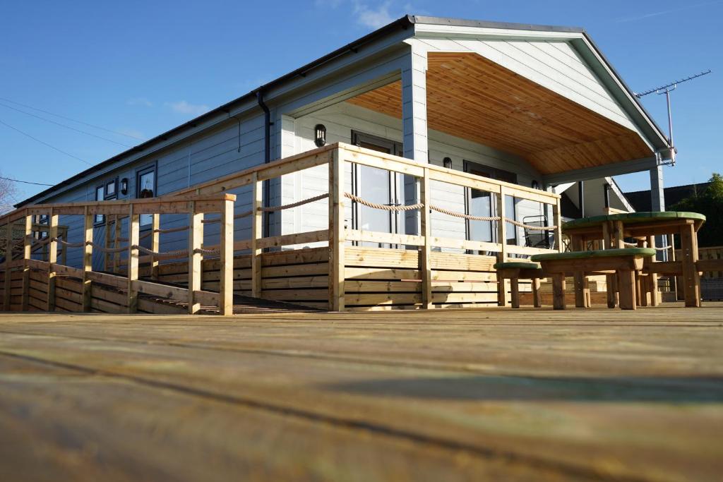 een huis met een grote veranda en een bank op een terras bij Ferry Lodge in Brundall