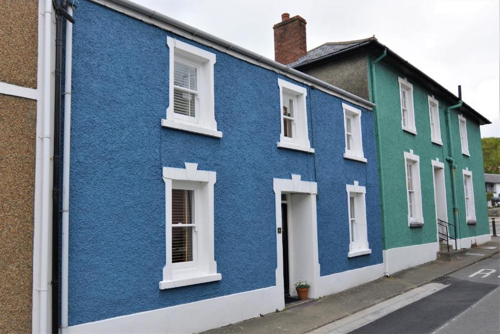 una fila de casas azules y verdes en una calle en Y Bwthyn Aberaeron en Aberaeron