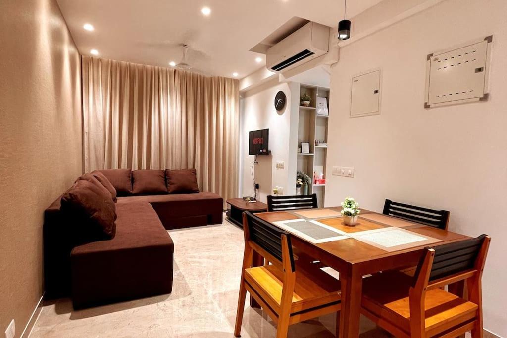 a living room with a table and a couch at Prime 1 BHK in Hiranandani Powai in Mumbai