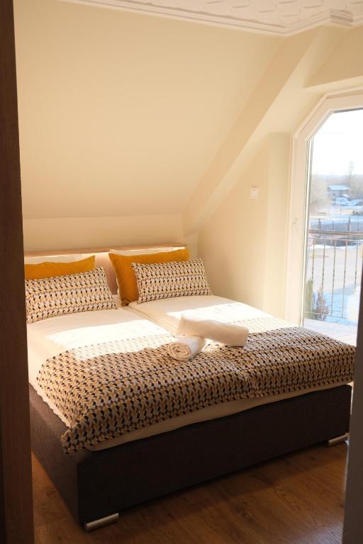 uma cama grande num quarto com uma janela em Trón Apartman em Siklós