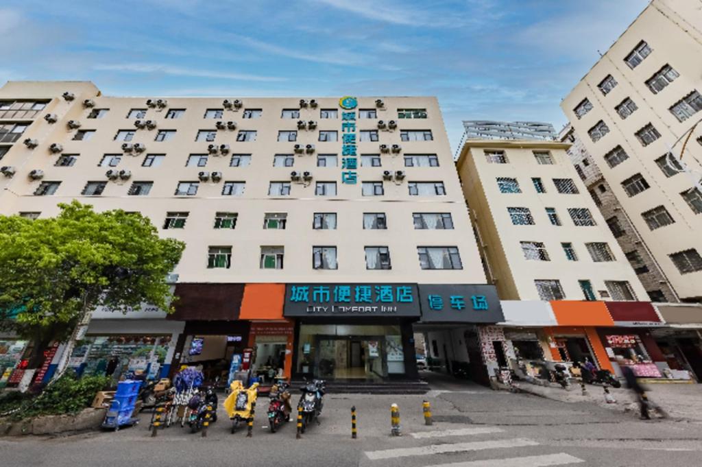 a large white building with motorcycles parked in front of it at City Comfort Inn Kunming Dashuying Yejin Hospital Wangdaqiao in Kunming