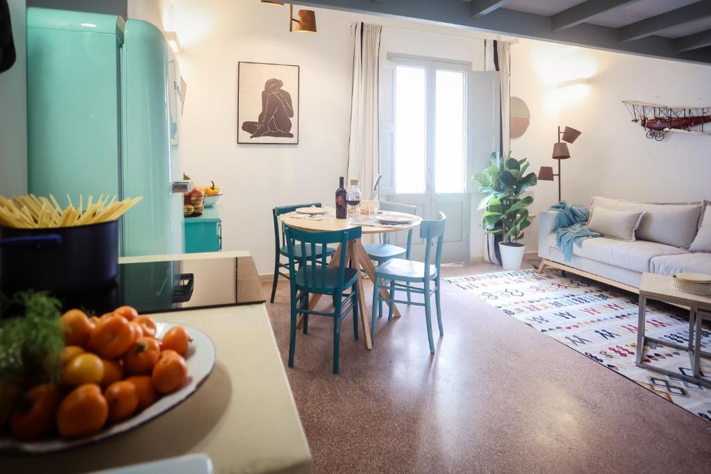 Il comprend une cuisine et un salon avec une table et des chaises. dans l'établissement Skafè Apartments, à Uggiano la Chiesa