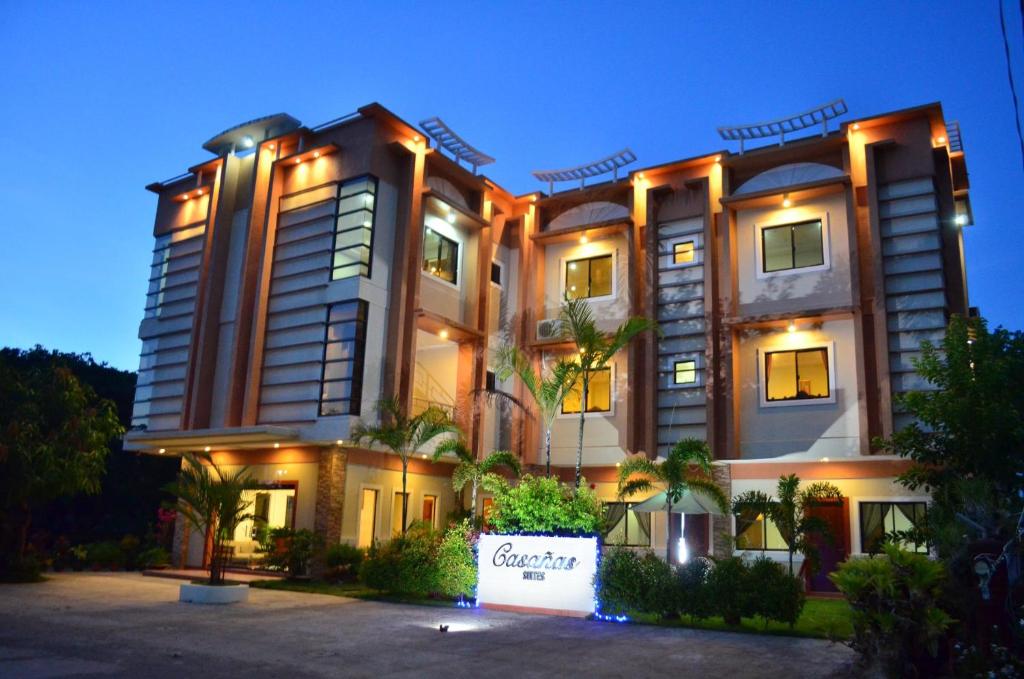 un grand bâtiment avec un panneau devant lui dans l'établissement Casañas Suites, à Puerto Princesa