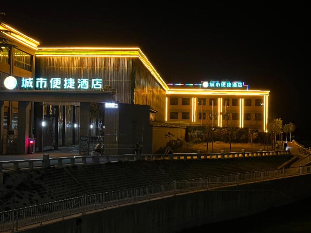un edificio con letreros de neón delante de él por la noche en City Comfort Inn Nanyang Nanshi Hospital, en Nanyang