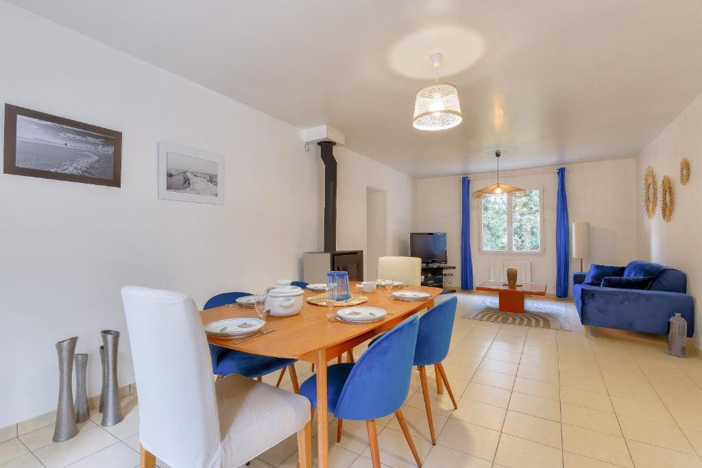 une salle à manger et un salon avec une table et des chaises dans l'établissement Séjour entre forêt et plage - Maison pour 7, à Saint-Hilaire-de-Talmont