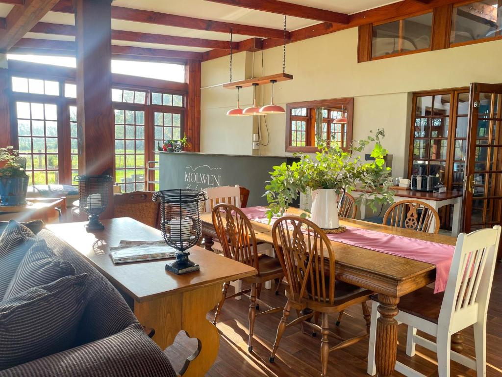 Molweni - Kamberg Valley B&B في Rev Estates: غرفة طعام مع طاولة وكراسي خشبية