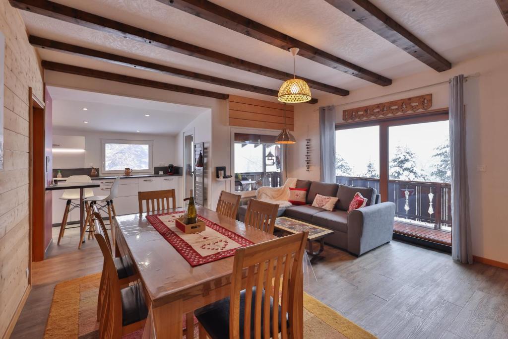 a living room with a couch and a table at Chalet au bois des écureuils classé trois étoiles. in Muhlbach-sur-Munster