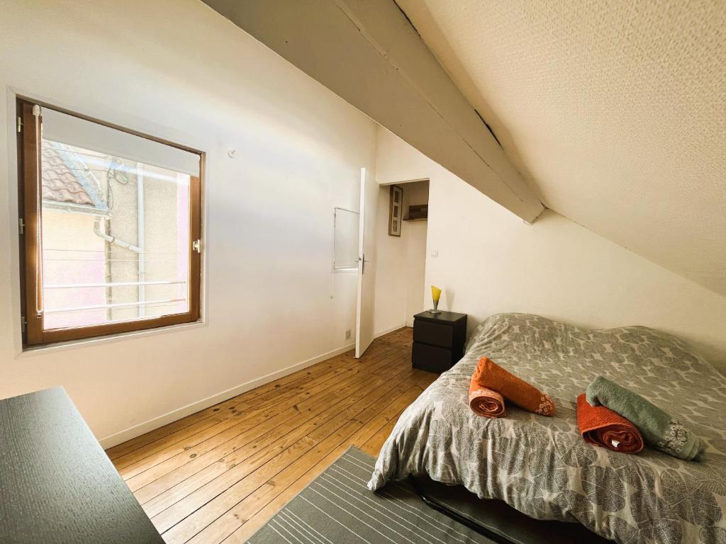 an attic bedroom with a bed and a window at Agréable maison de ville proche centre ville in Nantes