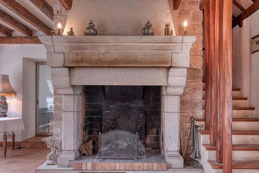 a stone fireplace in a living room with at Magnifique propriété en pierre in Sceaux-du-Gâtinais