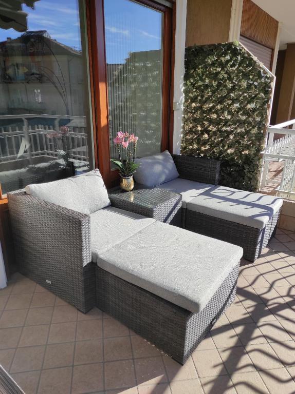 a patio with wicker furniture and a table and chairs at Appartamento al Sereno in Luino