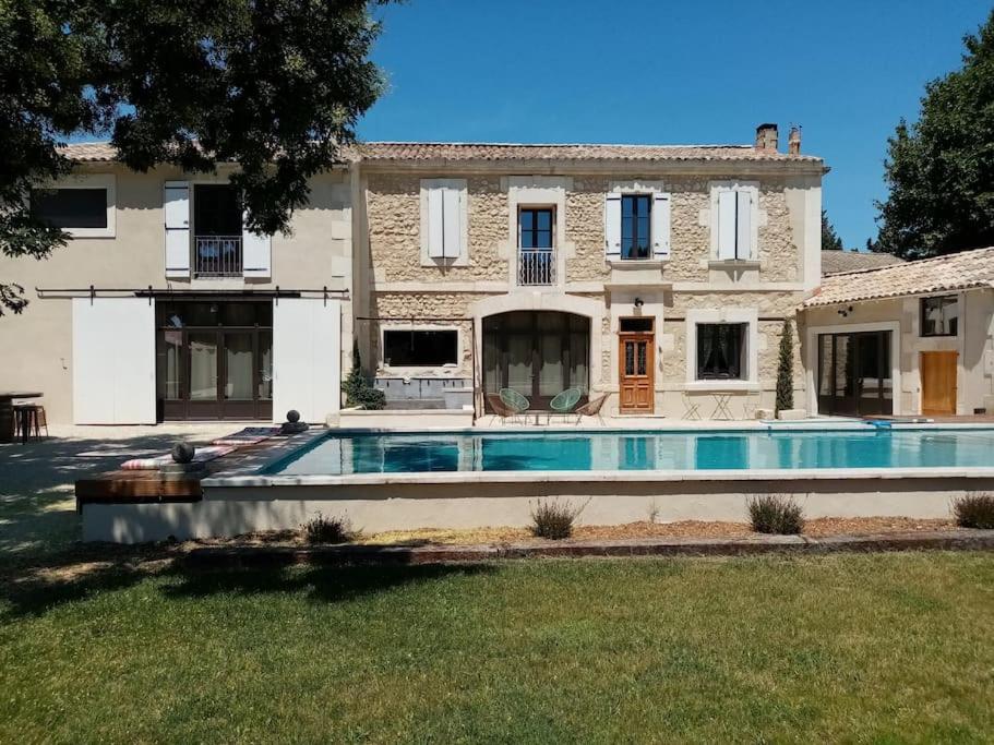 a large house with a swimming pool in front of it at Mas du Cuirassier- Vacances en Provence! in Châteaurenard