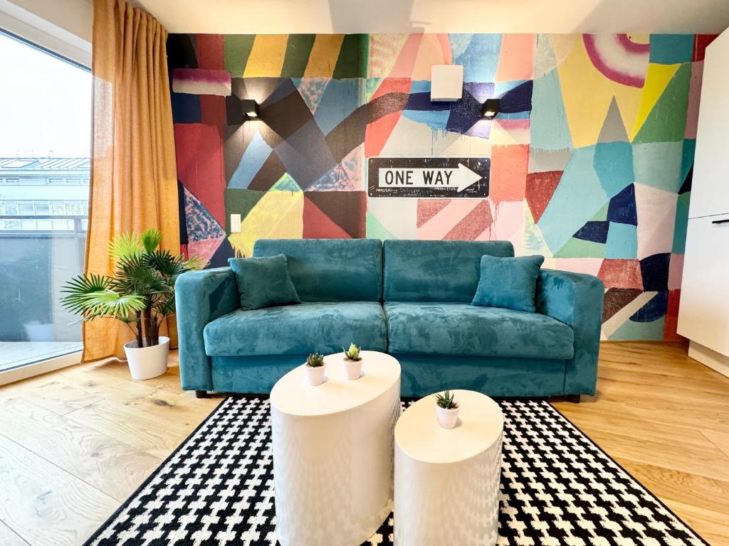 ein Wohnzimmer mit einem blauen Sofa und einem Wandbild in der Unterkunft Kreative Wohnung mit Balkon in Wien