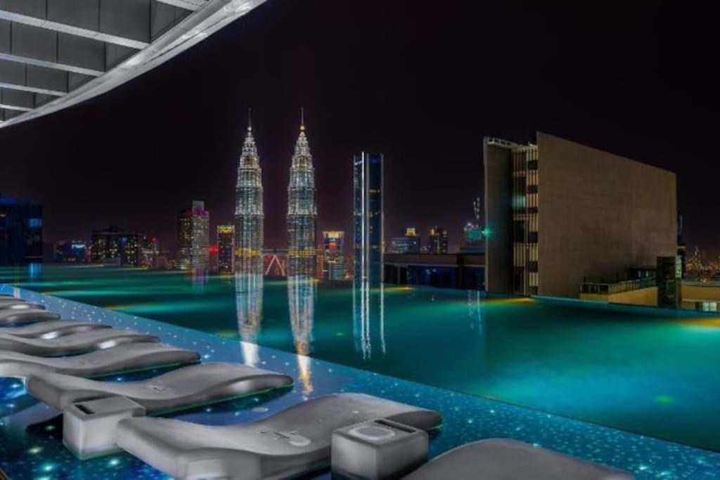 uma piscina com vista para a cidade à noite em NEW! Eaton Infinity SKY POOL KLCC view Pavilion em Kuala Lumpur