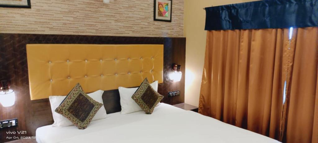 a bedroom with a large bed with white sheets and pillows at Varanasi Villa(B&B) in Varanasi