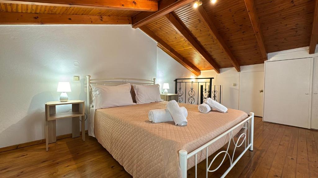 Un dormitorio con una cama con almohadas blancas. en Jason's House, en Corfú