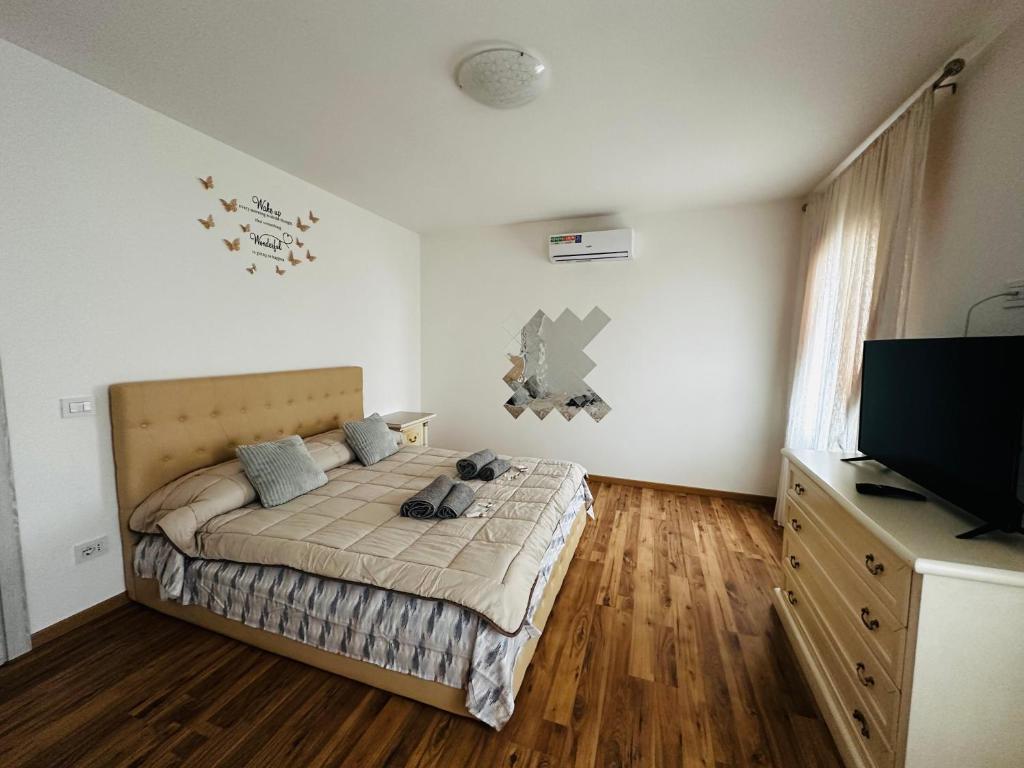 een slaapkamer met een bed en een flatscreen-tv bij La casa verde in Beccacivetta