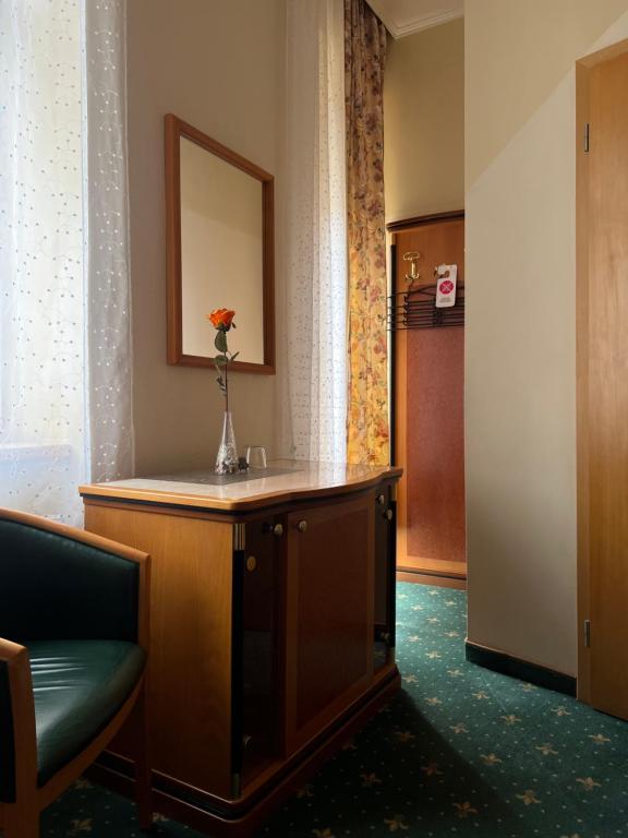 a hotel room with a desk with a vase of flowers on it at Hotel GEO in Prague