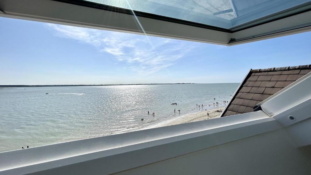 una vista sulla spiaggia dalla finestra di una casa di La caravelle, appartement pour 4 personnes a Le Crotoy