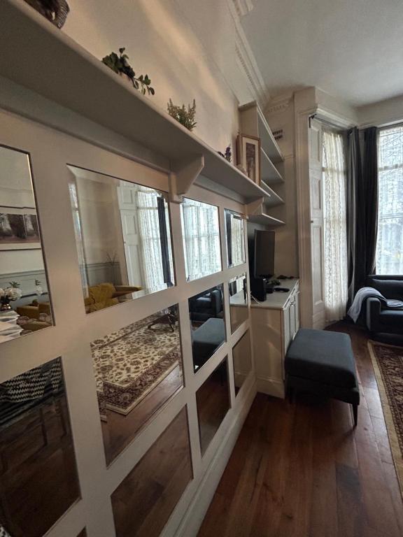 una sala de estar con una pared de puertas correderas de cristal en Modern Apartment in Holland Park, en Londres