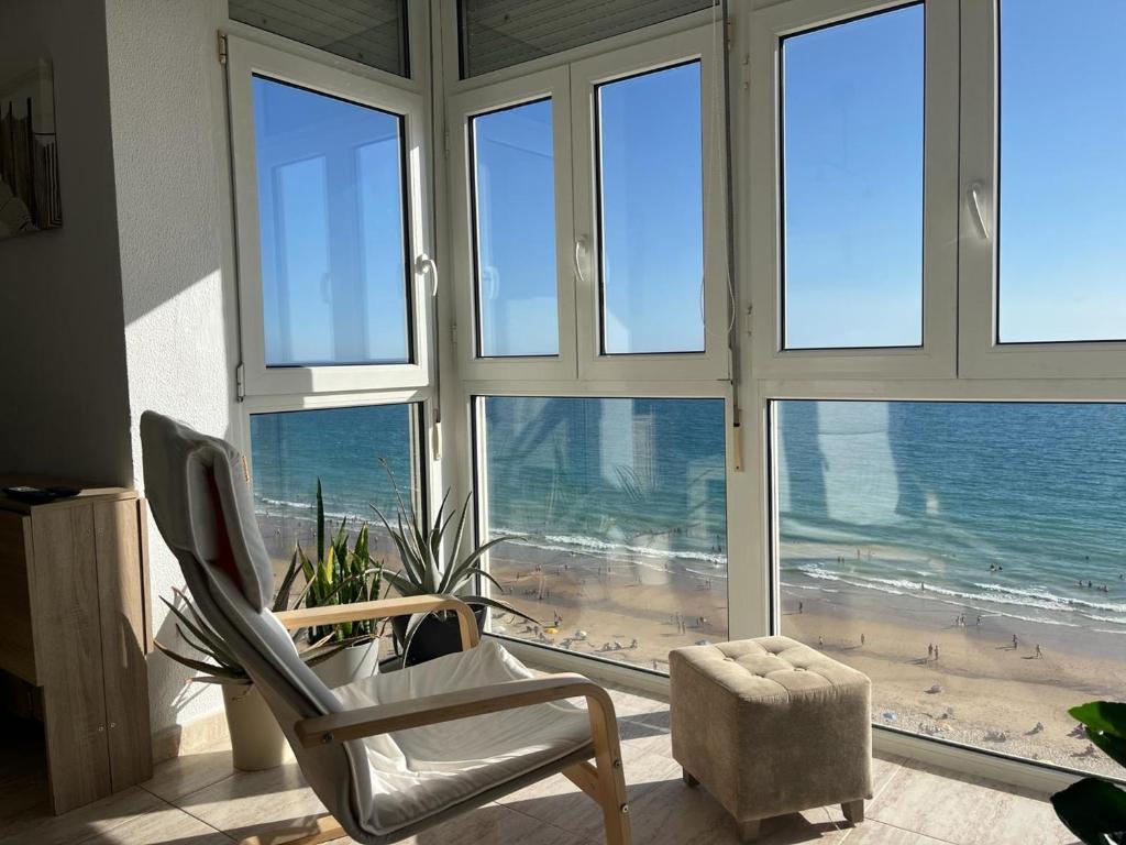 ein Wohnzimmer mit Blick auf den Strand von einem Fenster aus in der Unterkunft ARENA y Mar Sunny Home by Cadiz4Rentals in Cádiz