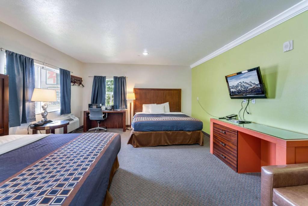 Cette chambre comprend deux lits et une télévision. dans l'établissement Ramada by Wyndham La Verkin Zion National Park, à La Verkin