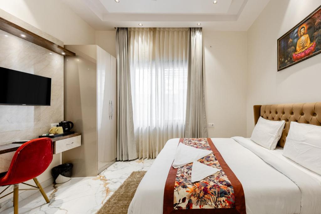 une chambre d'hôtel avec un lit et un fauteuil rouge dans l'établissement Lime Tree B&B Pari Chowk, à Greater Noida