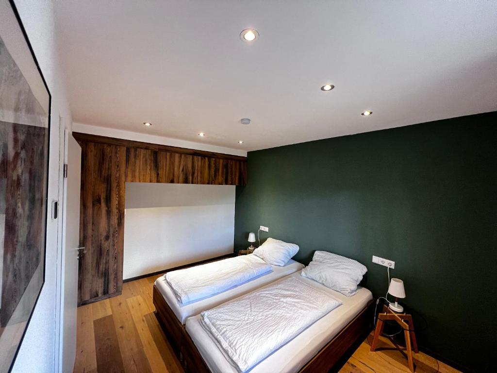 a bedroom with a green wall and a bed at Moderne Wohnung mit Ausblick in Niedernhall