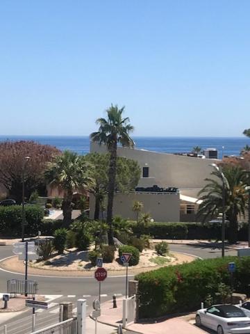 une voiture descendant dans une rue devant un bâtiment dans l'établissement T3 classé 3 * vue mer parking 100 m plage/ville, au Lavandou