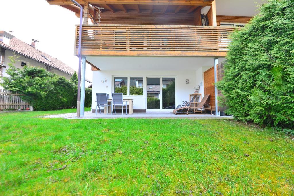 a patio with a table and chairs in a yard at Apartment on Zugspitzstrasse in Garmisch-Partenkirchen