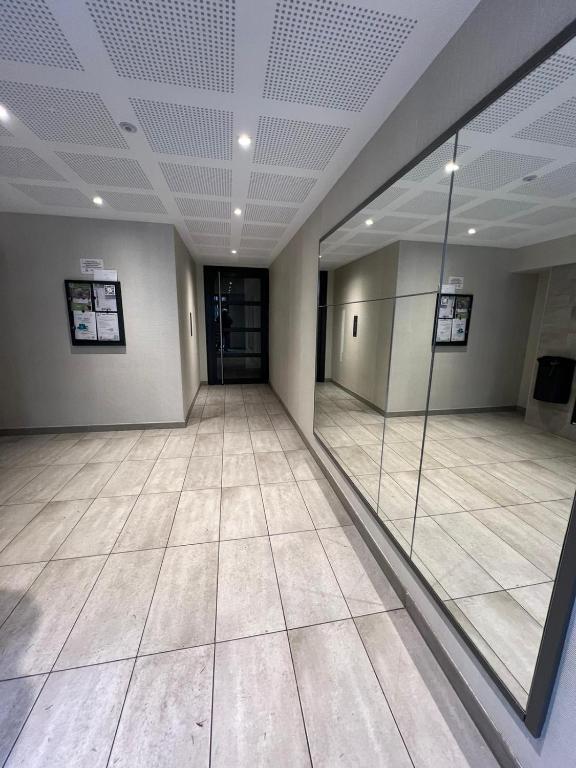 une grande pièce vide avec un grand miroir au plafond dans l'établissement Havre de paix, à Noisy-le-Roi