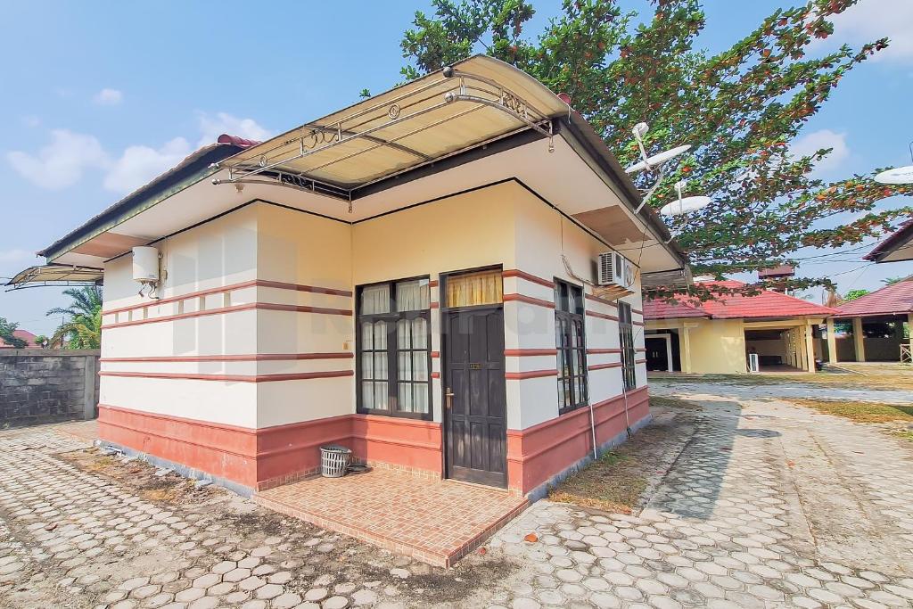 uma pequena casa com uma grande janela em Aman Guest House Redpartner em Palangkaraya