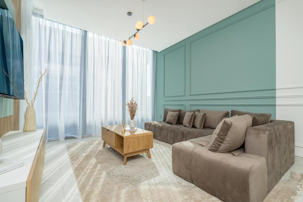 ein Wohnzimmer mit einem Sofa und einem Tisch in der Unterkunft Dar Alsalam - Modern Comforts in Dubai District One Residence 29 in Dubai