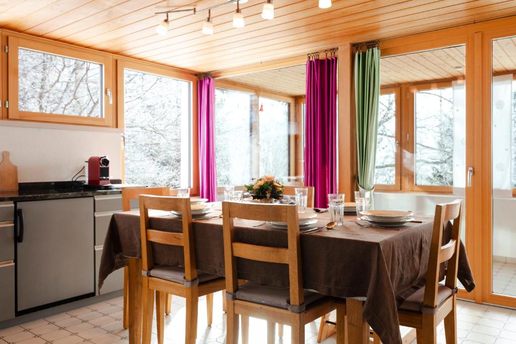 una cucina e una sala da pranzo con tavolo e sedie di Ferienhaus Casa Chapf ad Amden