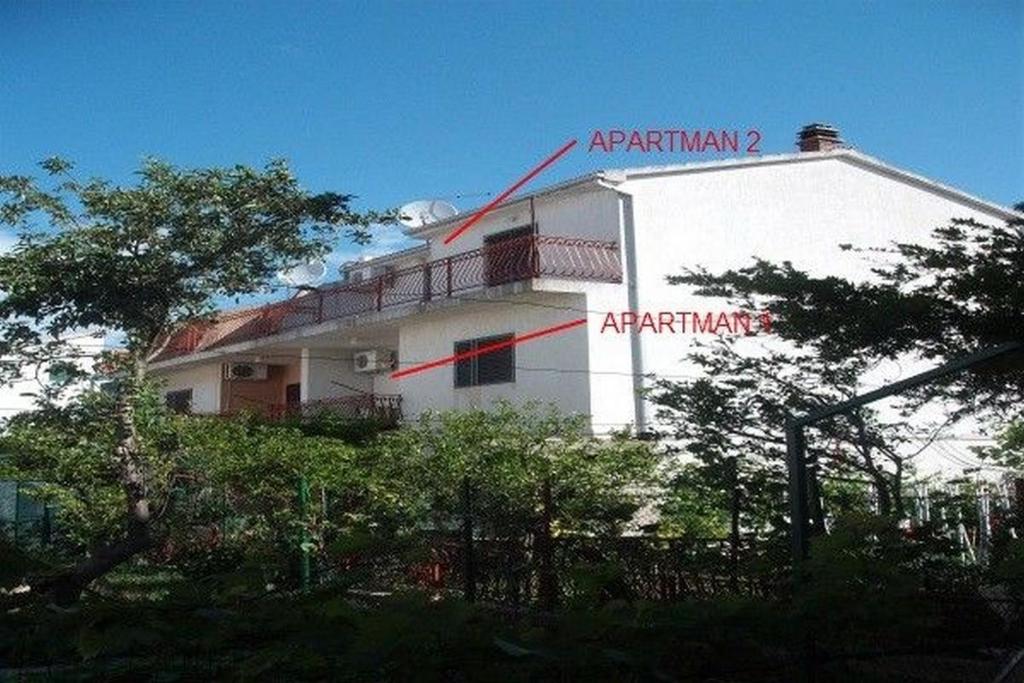 um edifício branco com um sinal na lateral em Apartments Ivan em Srima