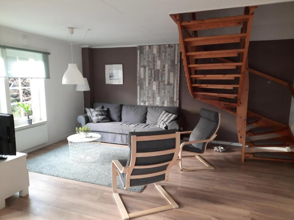 ein Wohnzimmer mit einem Sofa und einer Wendeltreppe in der Unterkunft Ferienhaus Landliebe, Wohnung 9048-3 in Dänschendorf