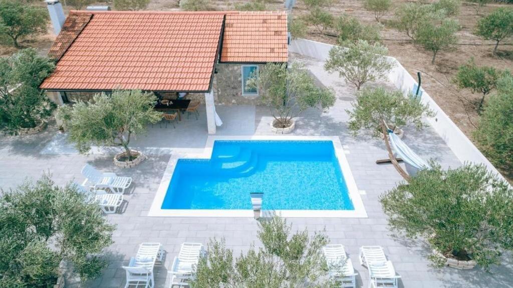 een uitzicht op een zwembad met stoelen en een huis bij House Villa Whisper of nature in Vodice