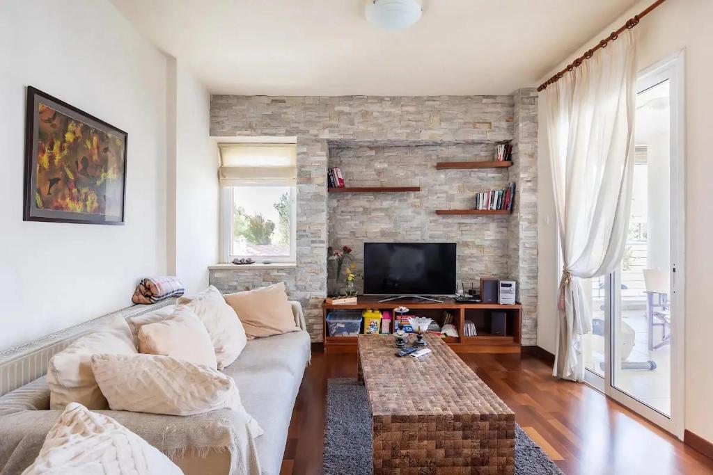 a living room with a couch and a tv at Warm Residence in the heart of the City Center - Balcony & view in Nicosia