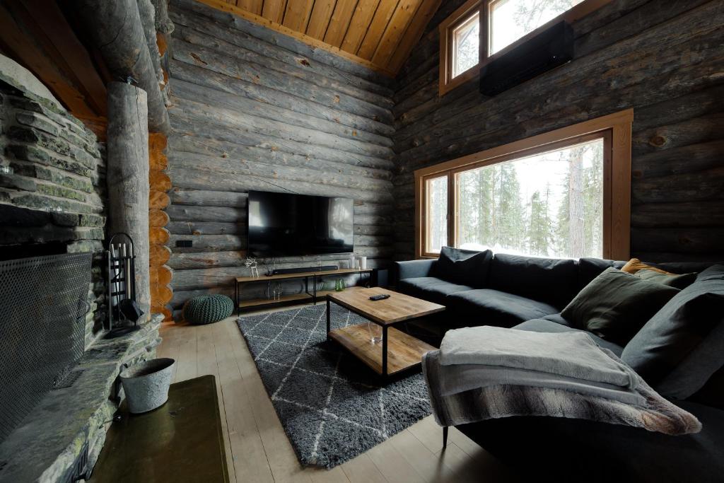 a living room with a couch and a tv at Kelokurki - The Luxury Lodge Where Serenity Meets the Northern Lights in Levi