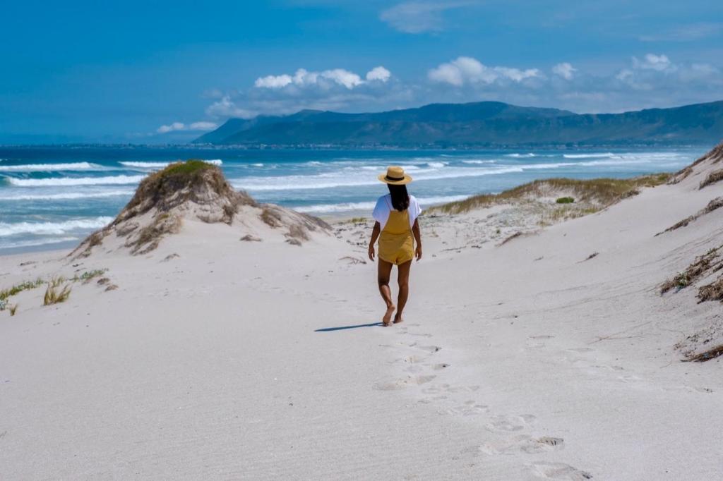 a woman walking on the beach at Calamari Self Catering in De Kelders