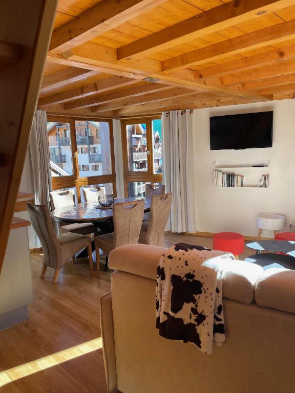 un salon avec un canapé et une table dans l'établissement PLEIN SUD AMBIANCE CHALET, à Valloire