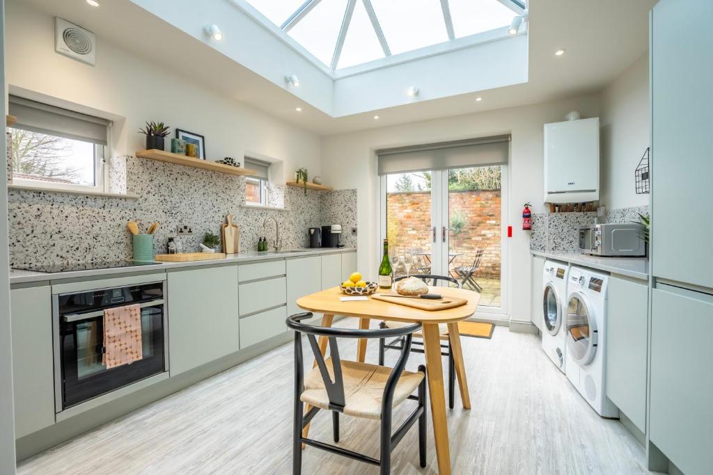 a kitchen with white cabinets and a table and chairs at The Smithy in York