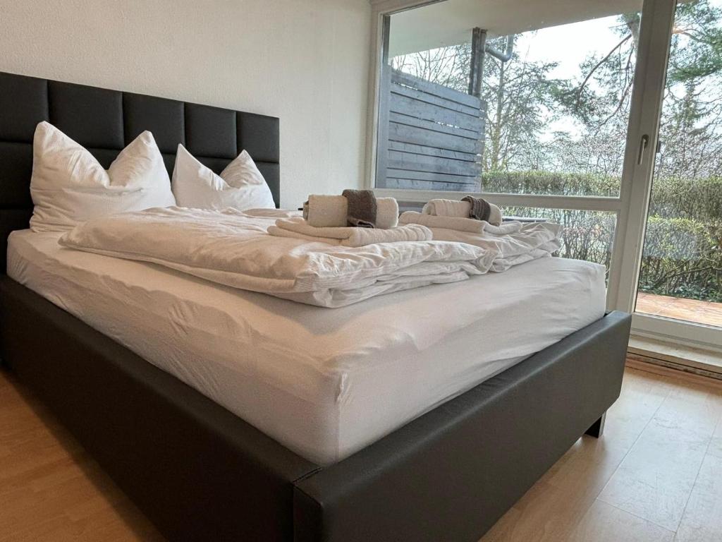 a large white bed in a room with a window at Stadtnahe Wohnung mit Terrasse in Höchberg