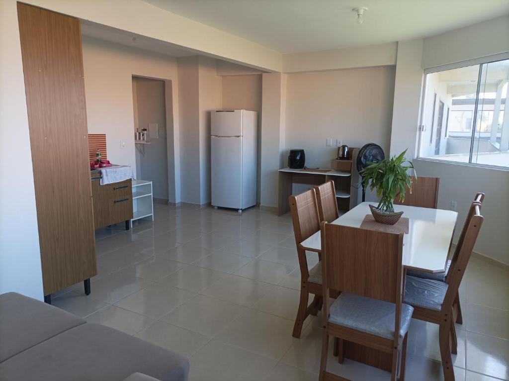 a kitchen and dining room with a table and a refrigerator at AP Beira mar in Laranjal