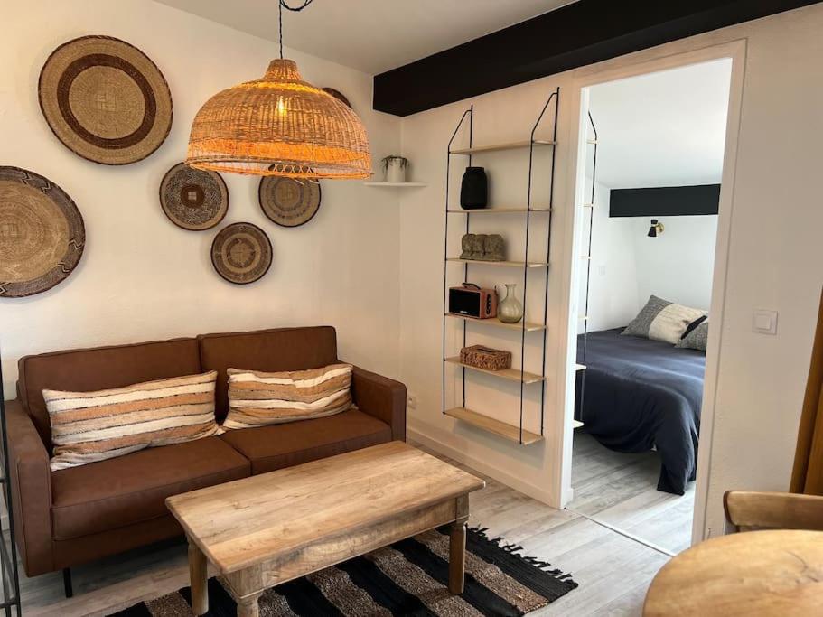 un salon avec un canapé et un lit dans l'établissement Le passage 75, à Montpellier