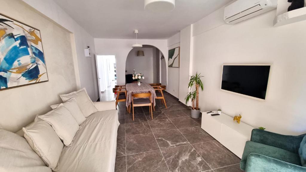 uma sala de estar com um sofá e uma mesa em Center 2Br Apt w/ parking and 250m walk from beach em Lárnaca