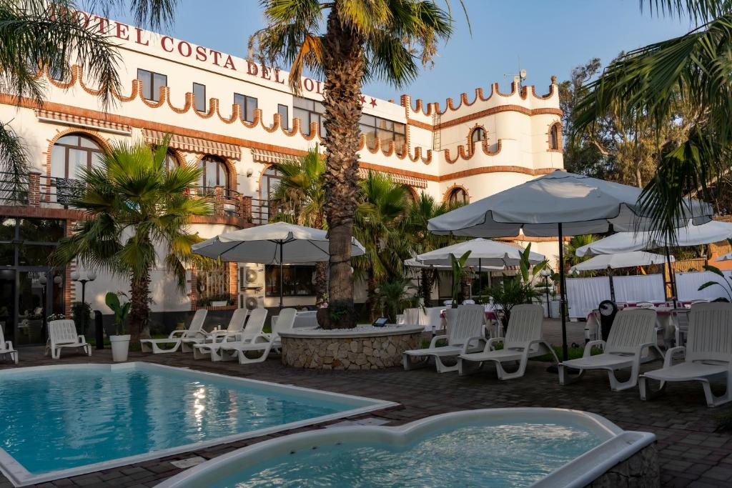 um hotel com piscina, cadeiras e guarda-sóis em Mg Palace Hotel Costa del Sole em Vaccarizzo - Delfino